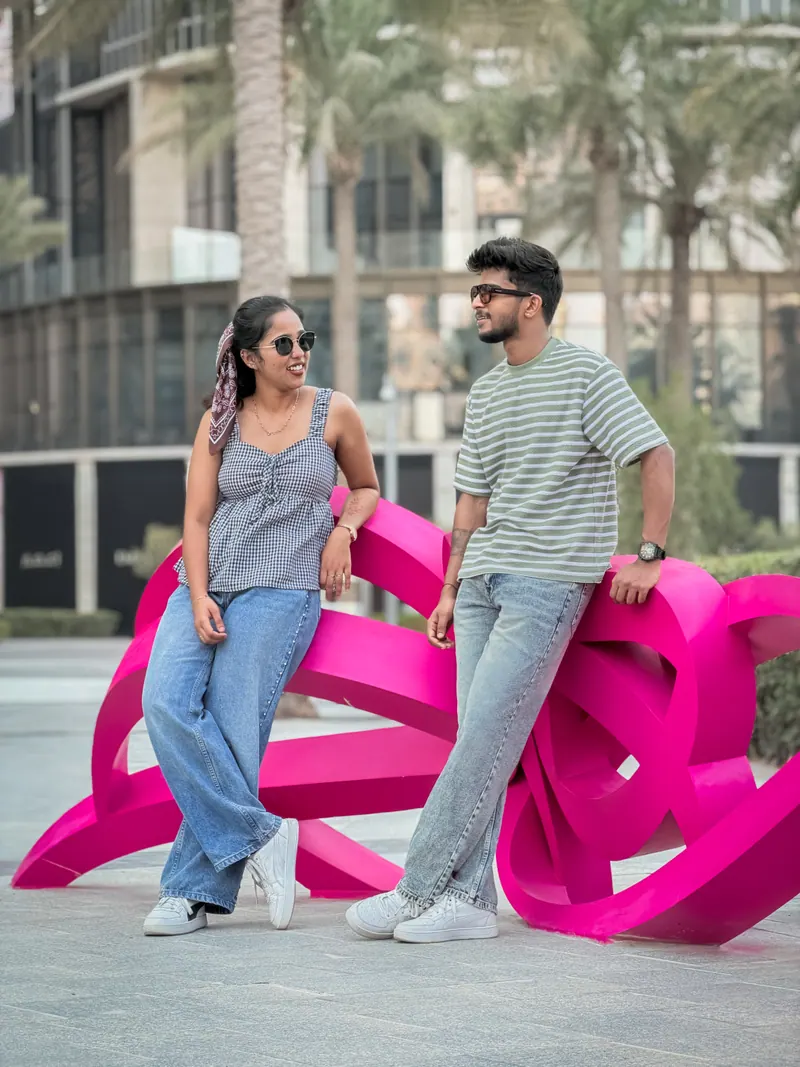 Alka and Jishnu leaning on a pink sculpture